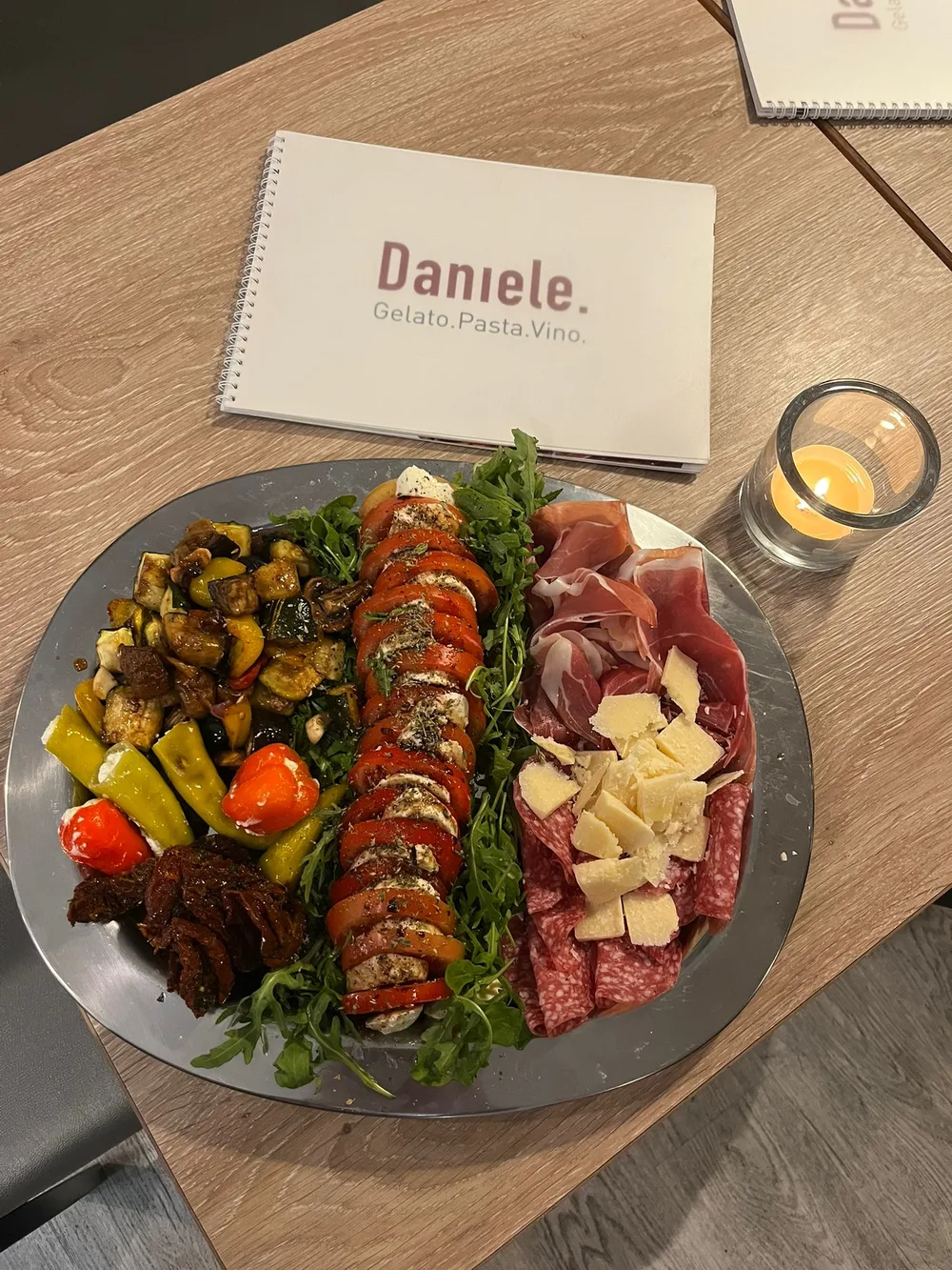 Italian antipasti with the words Daniele. Gelato. Pasta. Vino. in the background