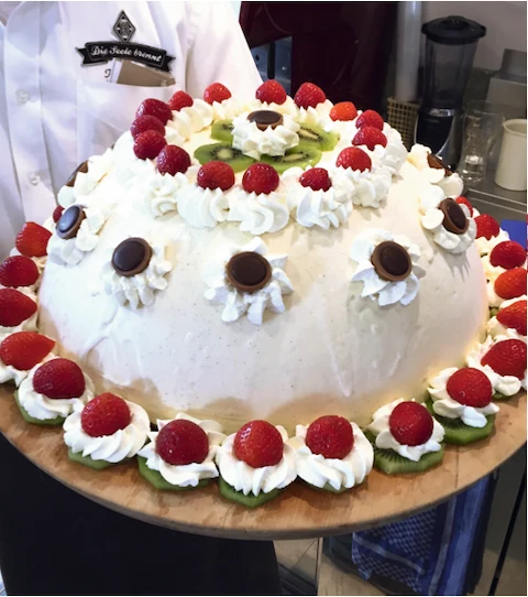 Celebration gelato cake with whipped cream, raspberries and kiwi